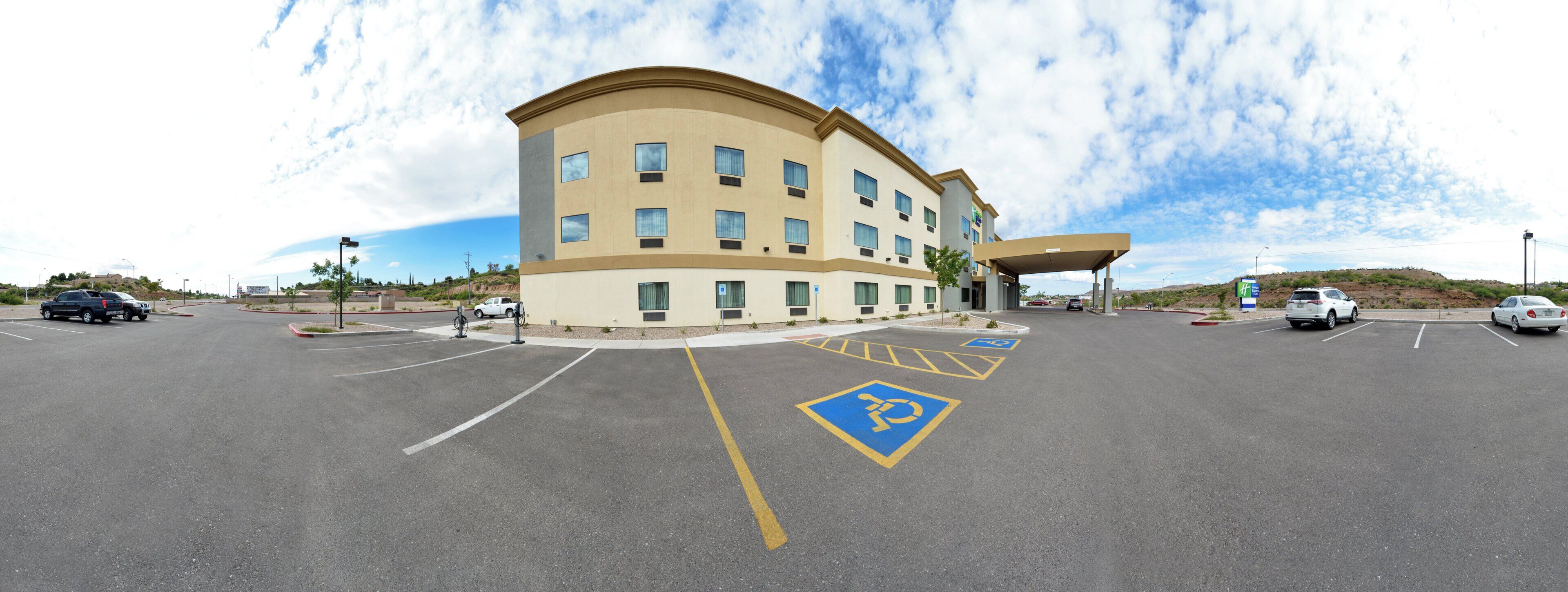 A multi-story hotel with a parking lot, handicap parking, and a covered entrance.