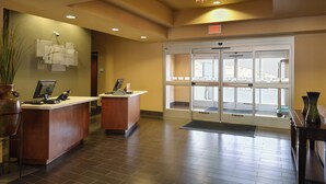 A hotel reception area with two reception desks, a large glass door entrance, and a view of the outside. - Holiday Inn Express & Suites Globe by IHG (Globe)