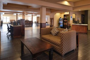 A spacious lobby with a sofa, a coffee table, a reception desk, and a dining area. - Holiday Inn Express & Suites Globe by IHG (Globe)