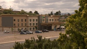 A multi-story hotel with a parking lot in front.