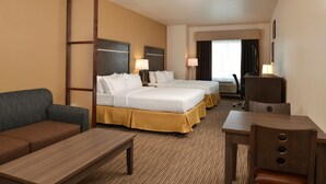 A hotel room with two beds, a sofa, a desk, and a chair.