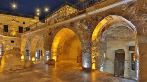 A historic courtyard with stone arches and a balcony with wrought iron railings. - Golden Cave Suites (Ürgüp)