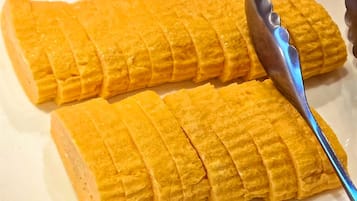 A rectangular plate with a yellow food item, possibly a cake or pastry, cut into strips.