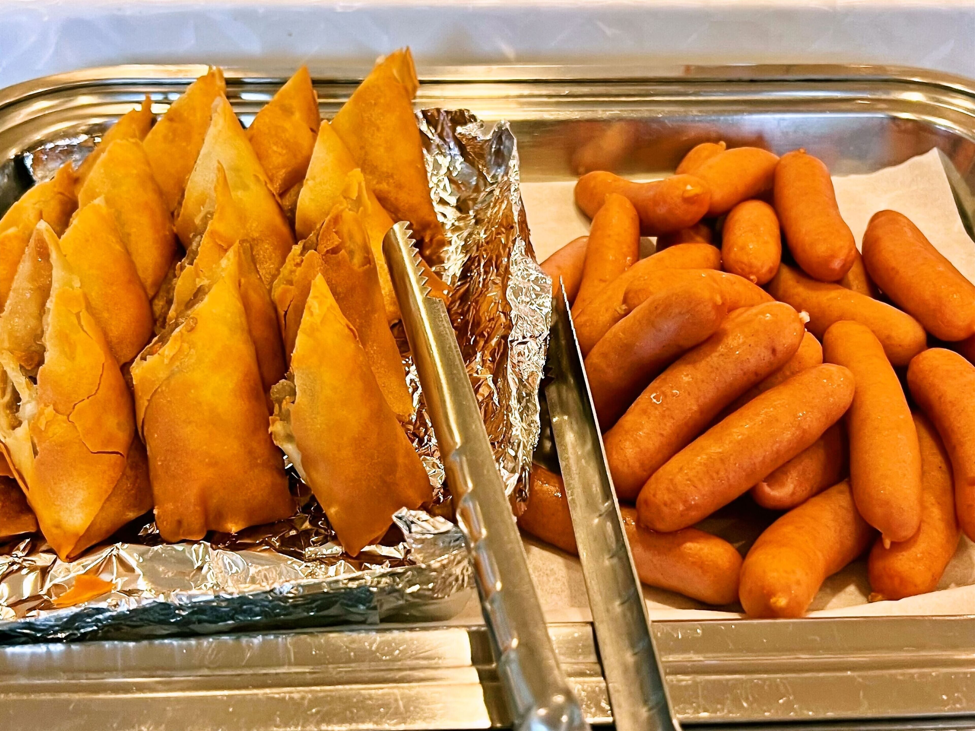 Un buffet con samosa e altri snack.