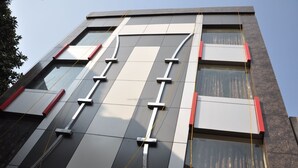A modern building facade with large windows and a geometric pattern of black and white tiles. - Hotel Robin (Amritsar)