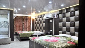 A hotel room with two beds, a large mirror, an air conditioning unit, and a shower area. - Hotel Robin (Amritsar)