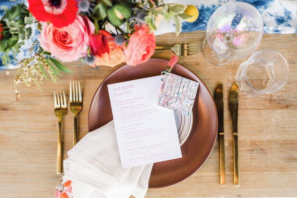 A table setting with a menu, cutlery, and a glass of water.