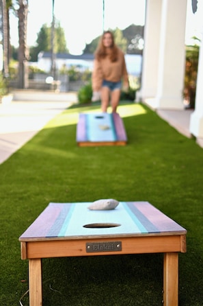 A small wooden table with a nameplate labeled 'Elakai' on a grassy lawn.