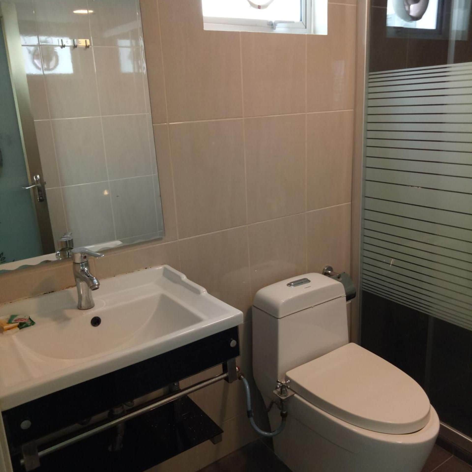 A bathroom with a white sink, a toilet, and a mirror.