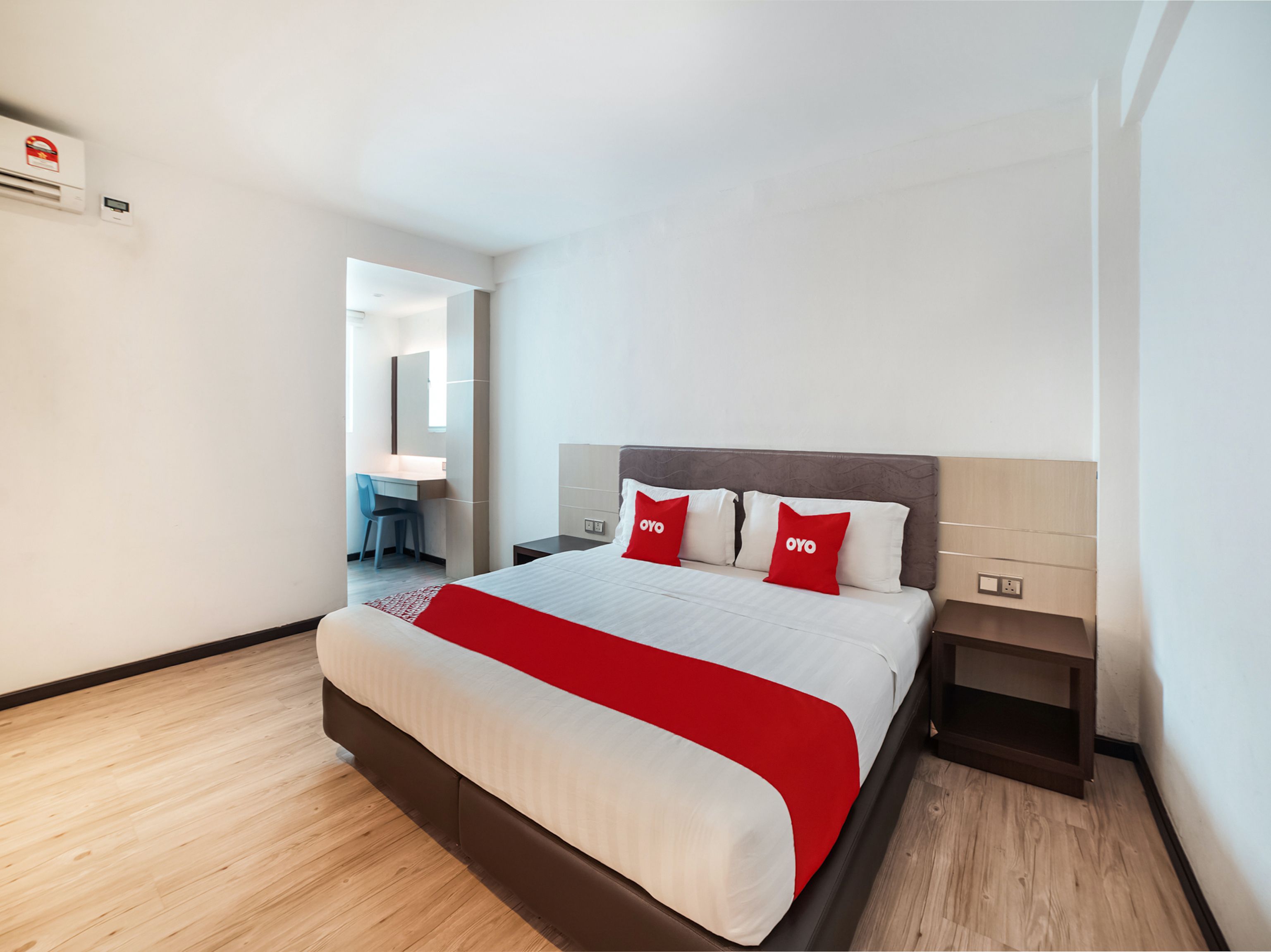 A hotel room with a bed, bedside tables, a desk, and a chair.