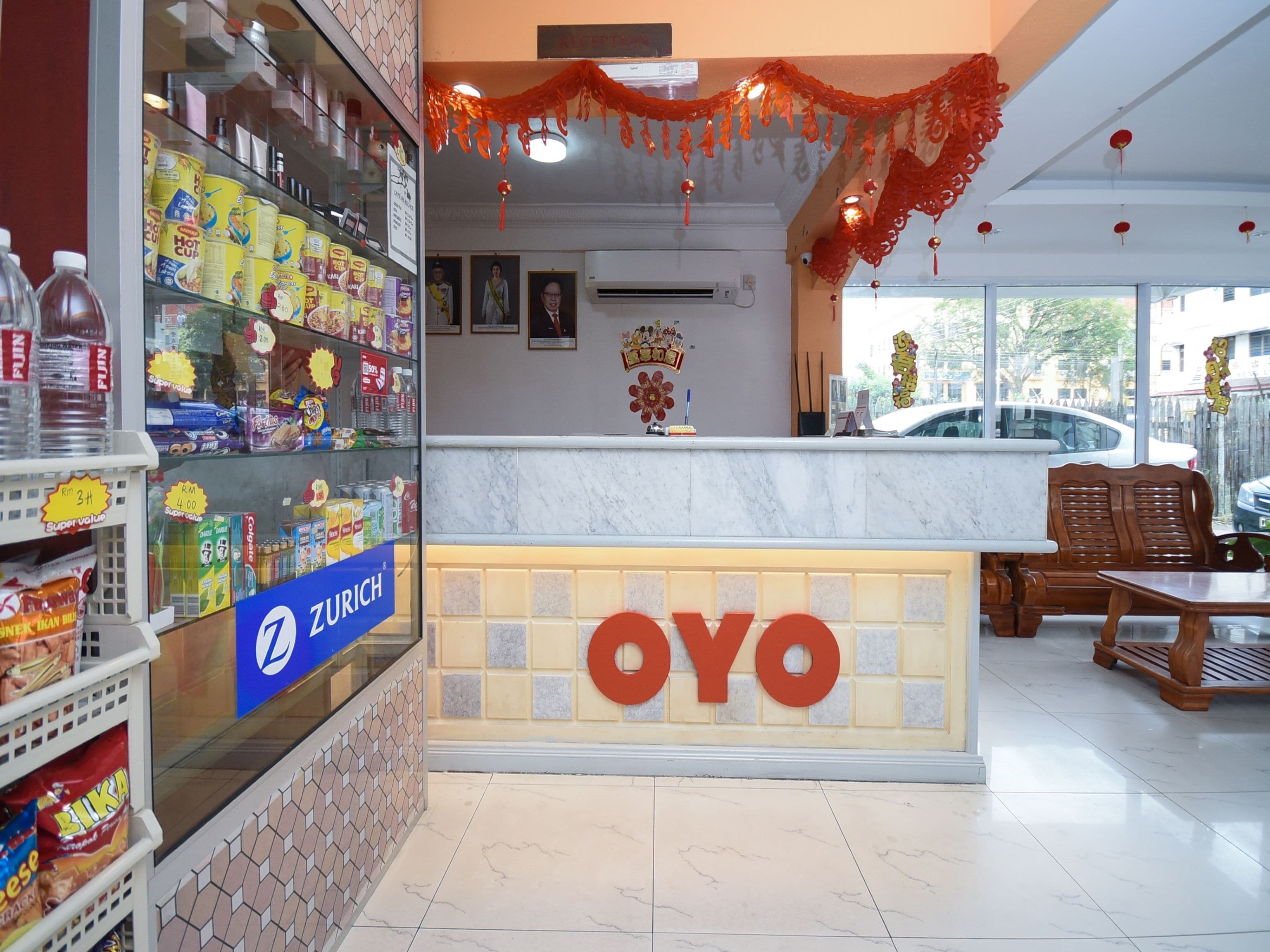 A restaurant interior with a counter, seating area, and various food items on display.