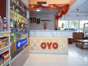 A restaurant interior with a counter, seating area, and various food items on display. - OYO 43970 Palace Inn (Miri)