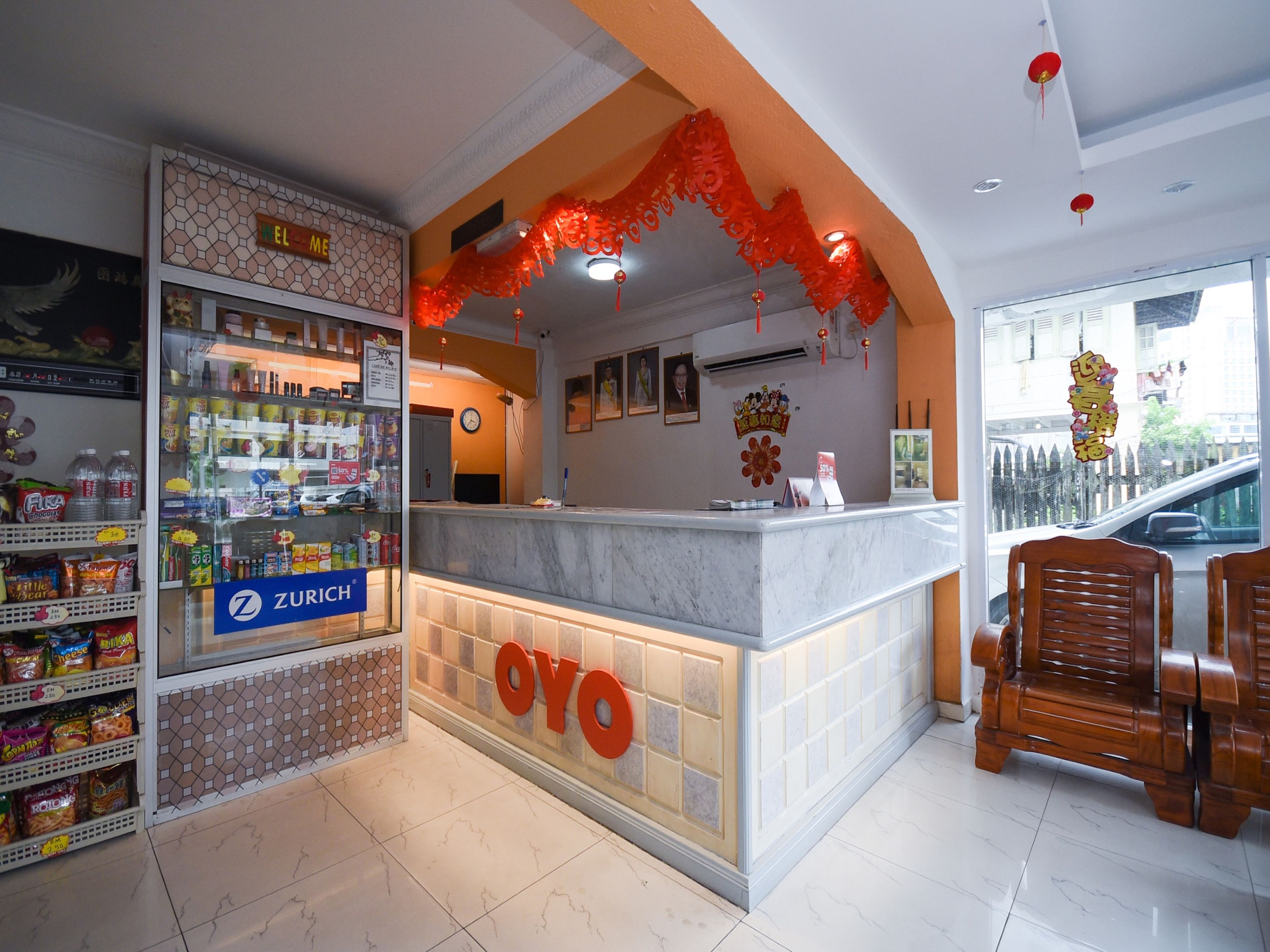 A reception area with a marble counter, a clock, and a sign for 'Zurich'.