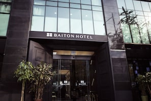 Das Baiton Hotel mit großen Glasfenstern und einer modernen Fassade.