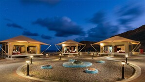 A series of tents with a central water feature, surrounded by a gravel area and pathways. - Ras Al Jinz Turtle Reserve (Al Hadd)