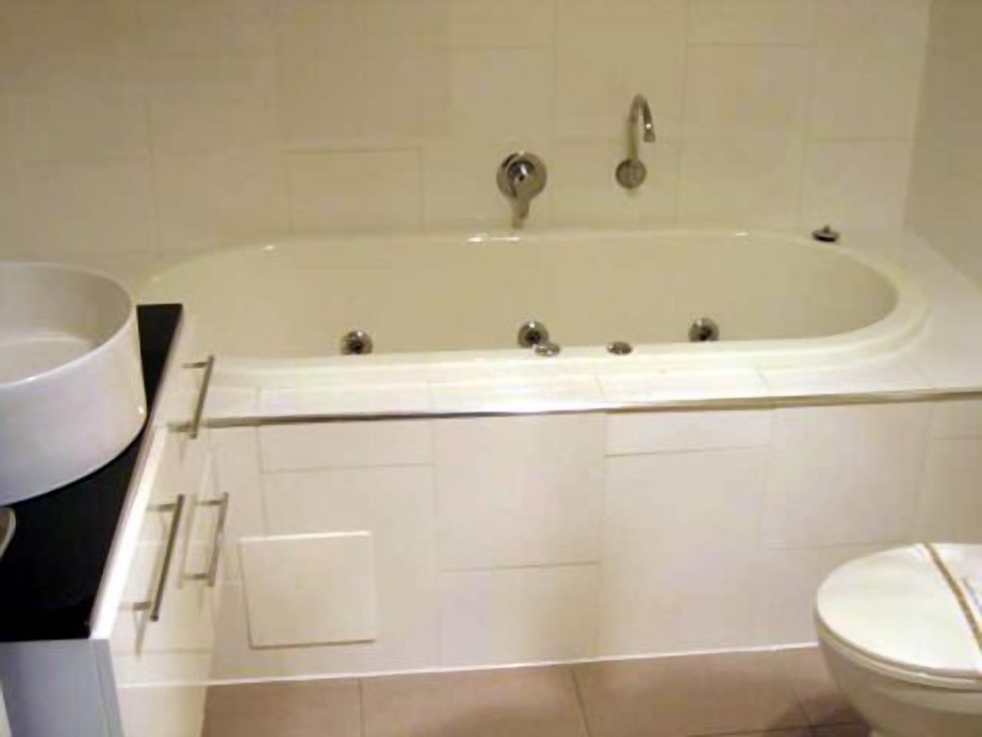 A bathroom with a bathtub, a toilet, and a sink.