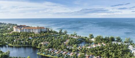 A resort with a large building, a lake, and a beach.