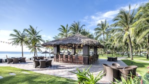 A beachside bar area with outdoor seating and a thatched roof structure. - Vinpearl Resort & Spa Phu Quoc (Phu Quoc)
