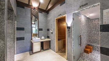 A modern bathroom with a sauna, a large mirror, and a wooden bench.