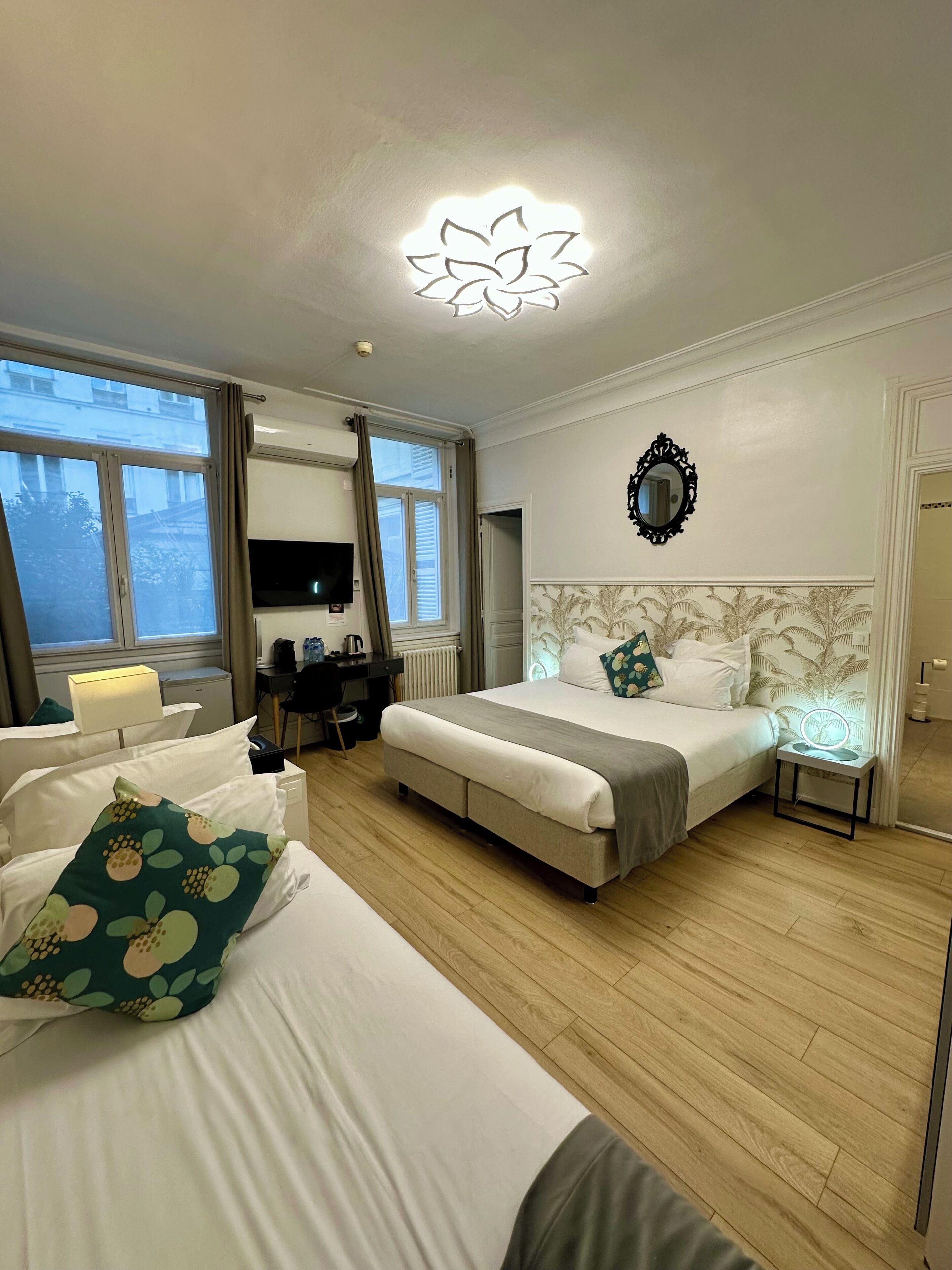 Habitación de hotel con cama, escritorio, televisión y baño.