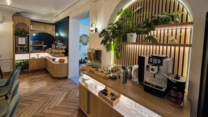 Un café moderne avec un plancher en bois disposé en motif de chevron, une machine à café et une variété de produits alimentaires exposés.