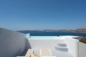A modern outdoor terrace with a pool, white walls, and a view of the sea and cliffs. - Goulielmos Hotel & Spa (Santorini)