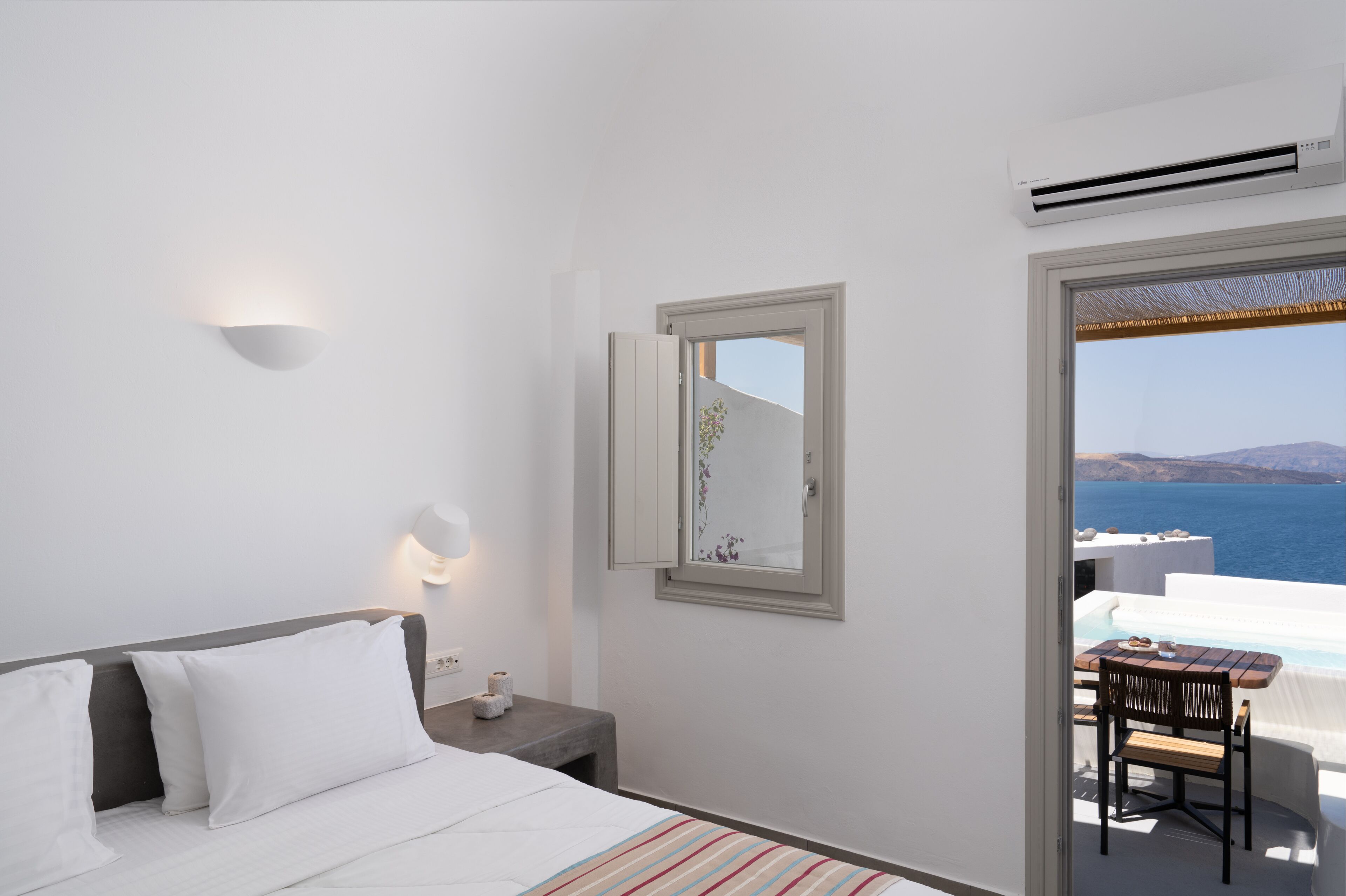 Ein Hotelzimmer mit Bett, Nachttisch, Spiegel und Meerblick.