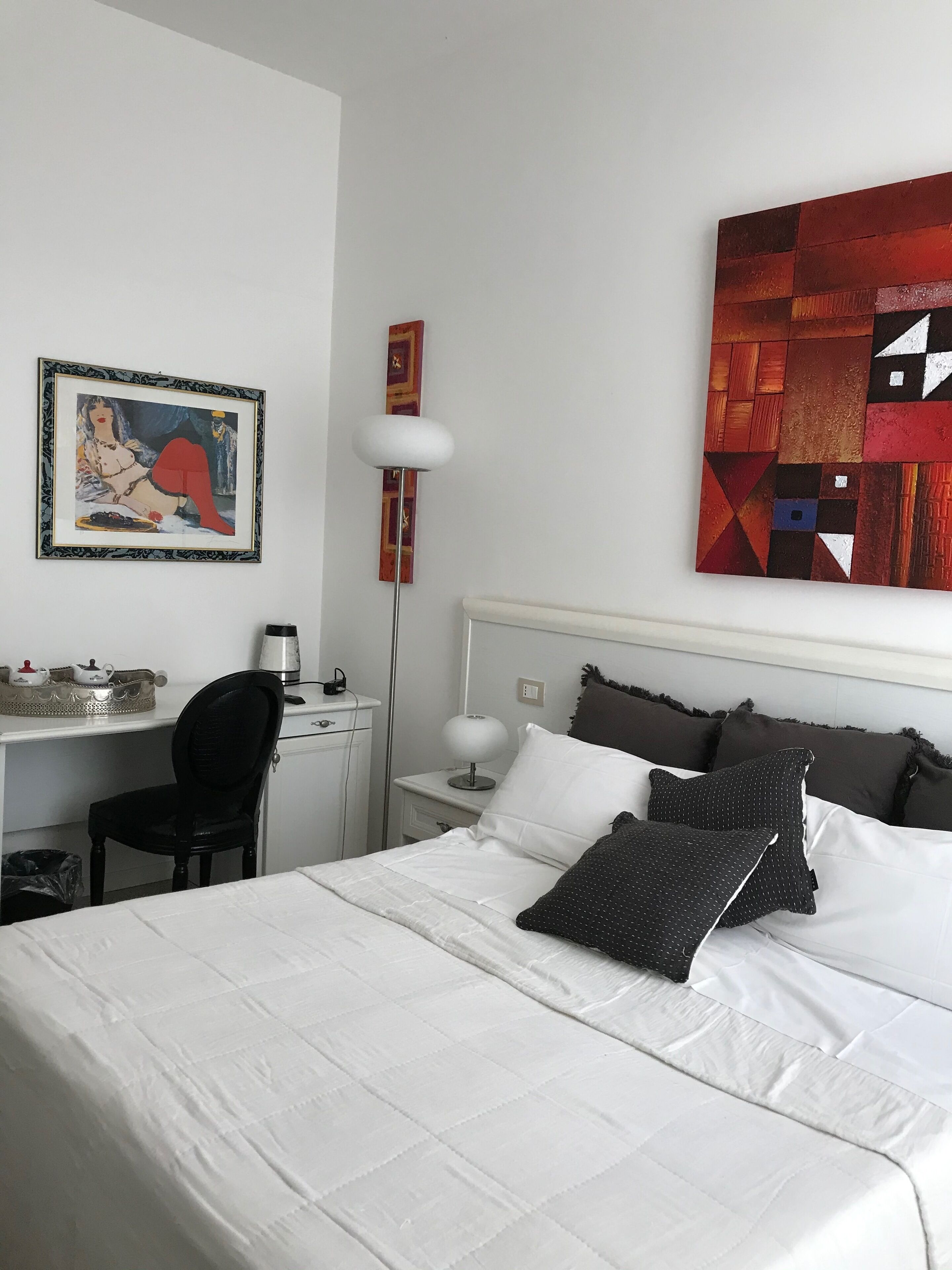 Habitación de hotel ordenada con cama, escritorio y silla.