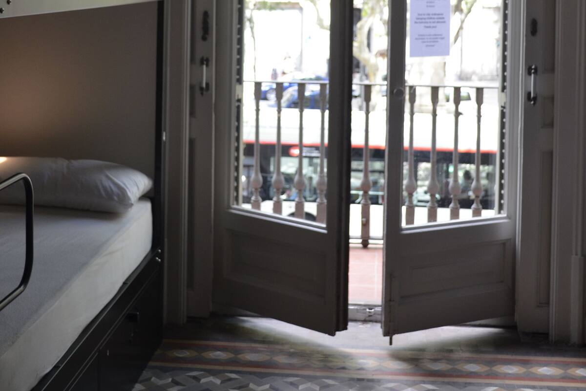A room with a bunk bed, a door leading outside, and a patterned floor.