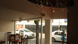A room with a large window, a wooden dining table, and chairs. - Vivaz Boutique Hotel (Recife)