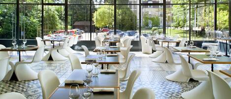 A restaurant with a modern interior, large windows, and a view of the outside.