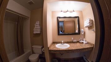 A bathroom with a sink, mirror, and toilet.
