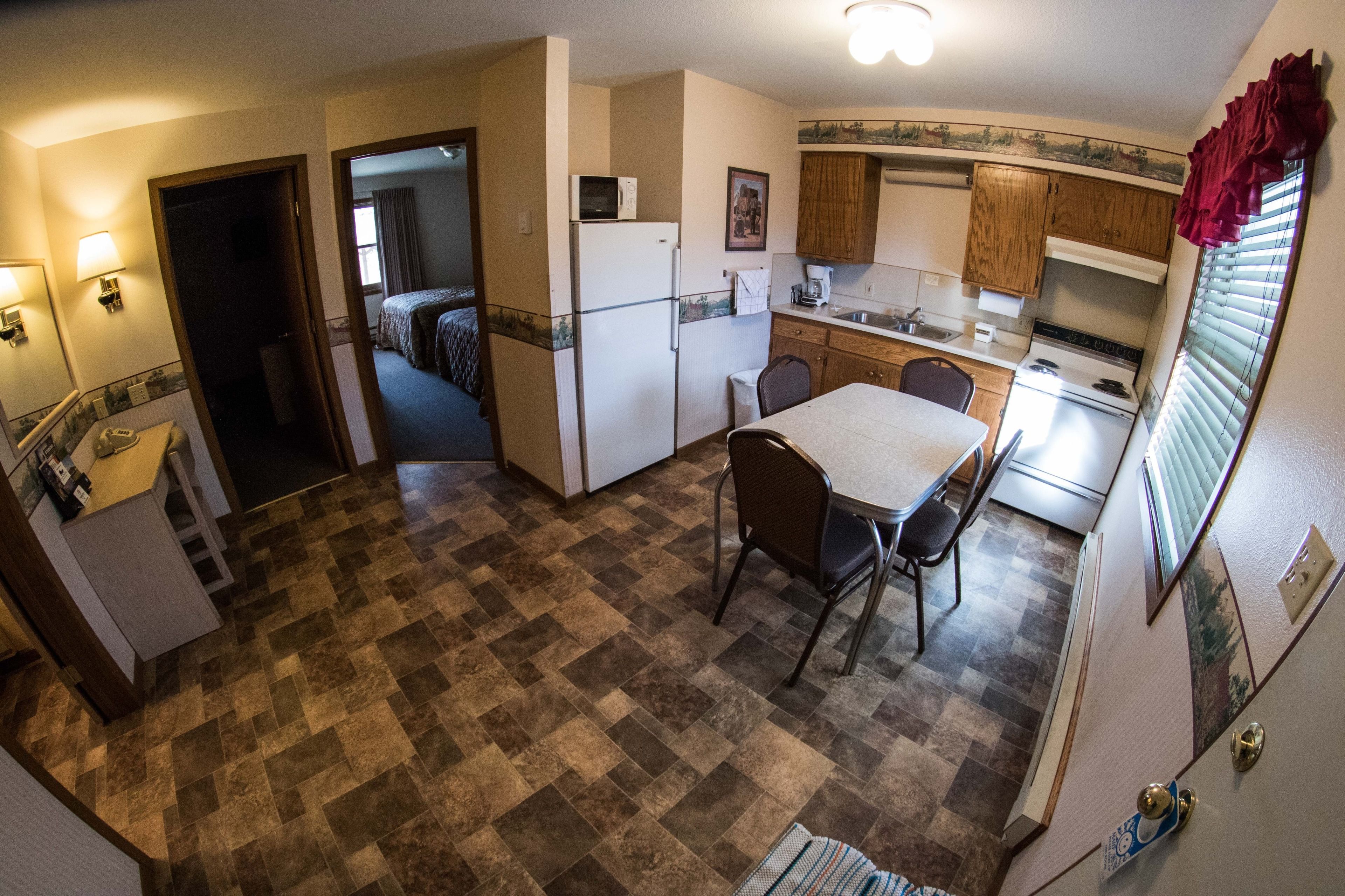 A compact kitchen with a refrigerator, stove, and dining area.