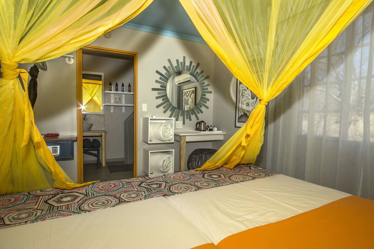 Um quarto com uma cama, uma escrivaninha e um espelho.
