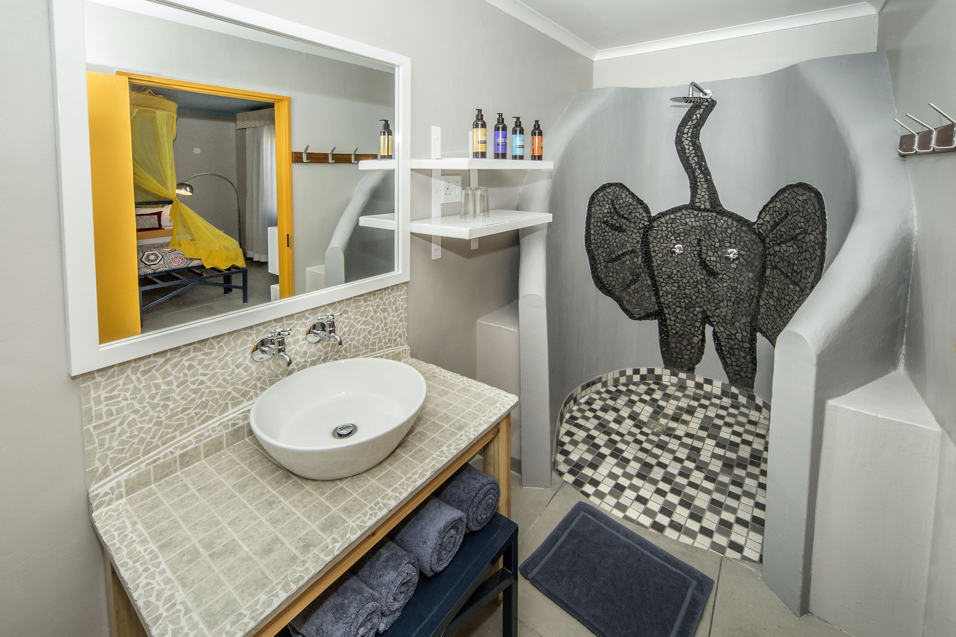 A bathroom with a white sink, a mirror, and a checkered floor.