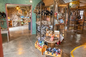 Ein gemütliches Boutique-Hotel mit Holzböden, einer Steinsäule und einer Auswahl an Stofftieren und Taschen.