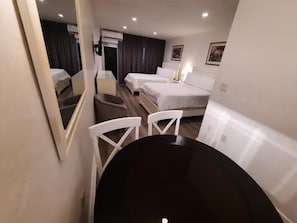 Une chambre d’hôtel avec un lit, un bureau, une chaise et un miroir.