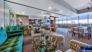A spacious lounge area with a mix of seating options, including sofas and chairs, a coffee table, and a dining area with tables and chairs. - Plaza Resort Club (Reno)