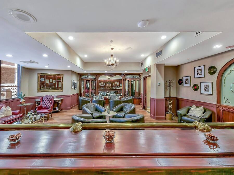 A spacious lobby with leather seating, a chandelier, and framed pictures on the walls.