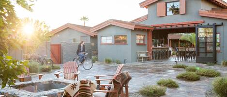 A patio area with outdoor seating, a fire pit, and a bicycle.