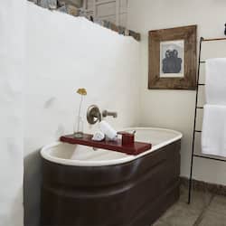 Bathroom features a bathtub, a wooden shelf, and a framed picture.