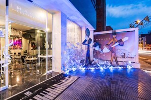 Un restaurant doté d’une façade en verre, dont l’entrée est ornée d’un motif représentant un clavier de piano, et sur lequel on peut lire l’inscription « Imagine Restaurant ».