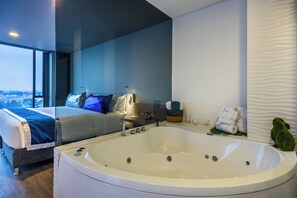 Une chambre moderne avec un grand lit, une baignoire et une vue sur la ville.