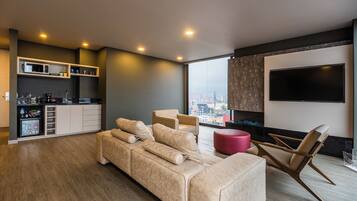 Una sala de estar moderna con un sofá, una mesa de centro y un televisor montado en la pared.