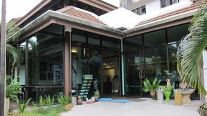 Un edificio moderno con amplios ventanales y una zona de acceso cubierta.
