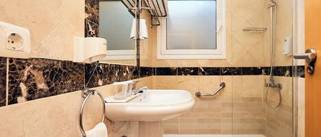 A modern bathroom with a sink, mirror, towel rack, shower, and toilet.