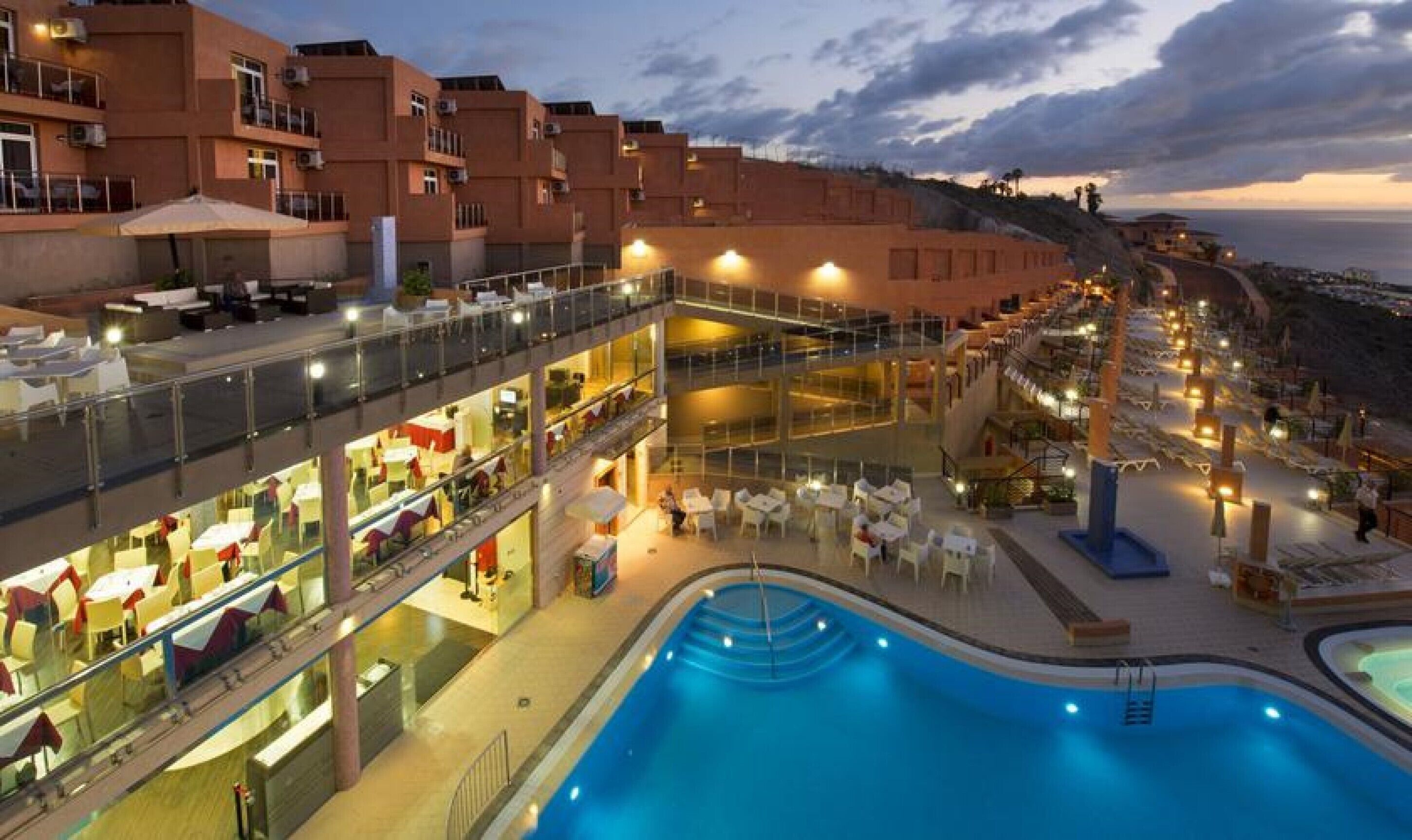 Un hôtel doté d’une piscine, d’un espace extérieur aménagé et offrant une vue sur la mer.