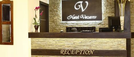 Eine Rezeption mit einer Steinfassade und einem Schild, auf dem 'Hotel Vozaruv' steht.