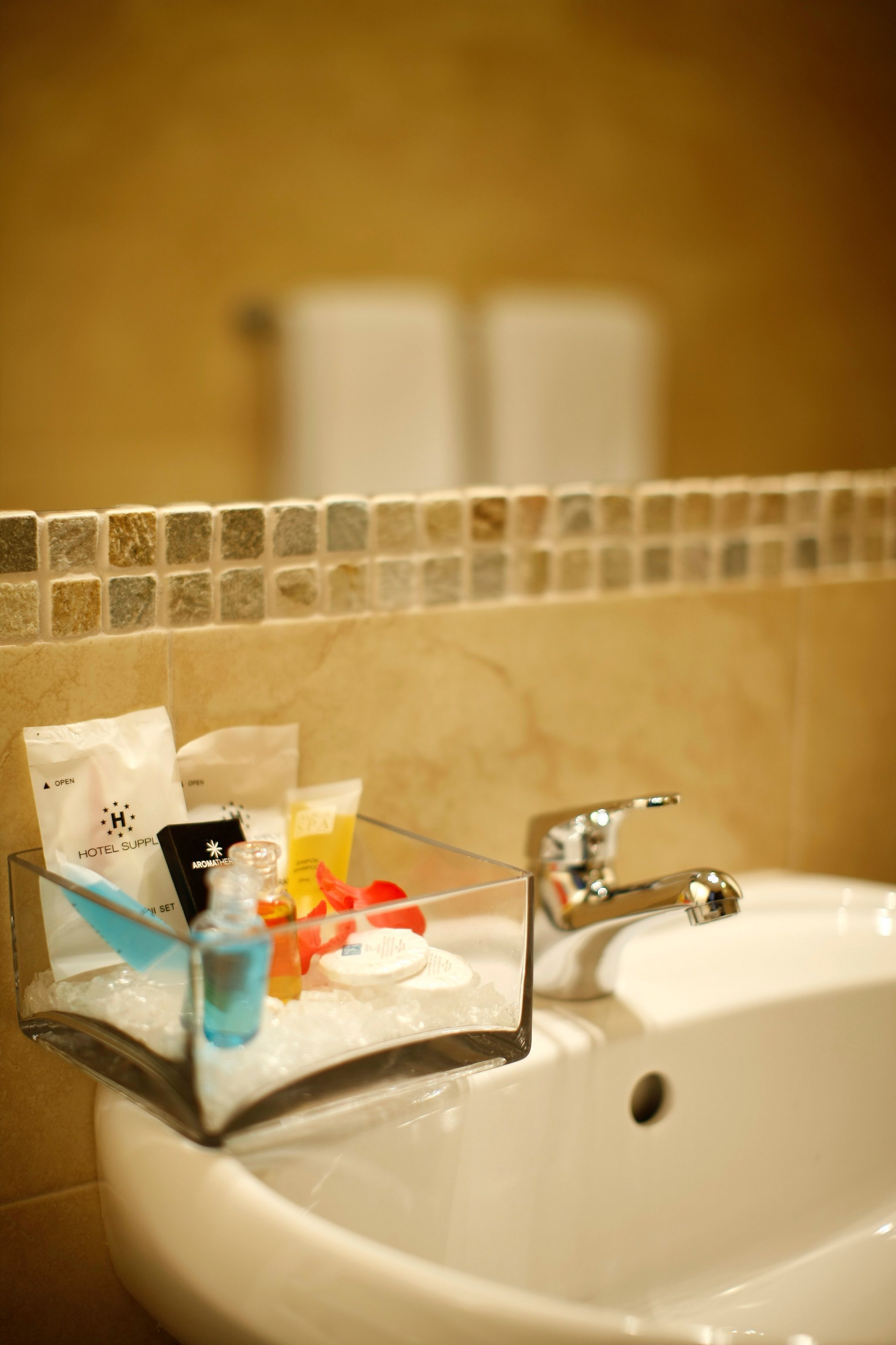 A bathroom sink with toiletries and a glass soap dish.