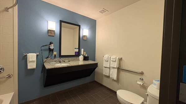 Une salle de bain équipée d’un lavabo, d’un miroir, d’un porte-serviettes et de toilettes.